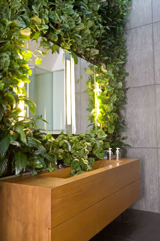 Vertical Garden with Artificial Plants Around Bathroom Mirror